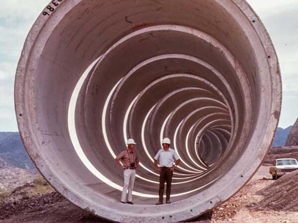 Men stand in a very large tunnel