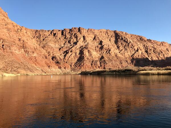 Desert river with canyon behind.