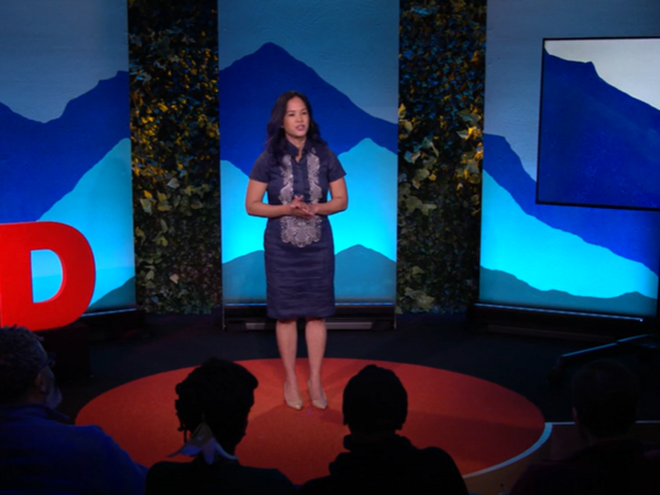 A woman speaks from a stage