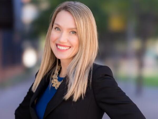 Woman with blond hair smiles into the camera.