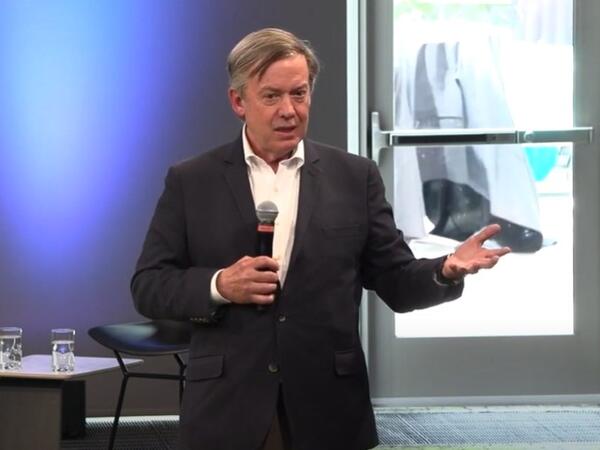 A man stands on a stage holding a microphone.