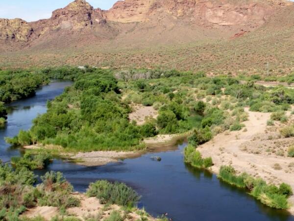 A blue ribbon river flows through an arid landscape