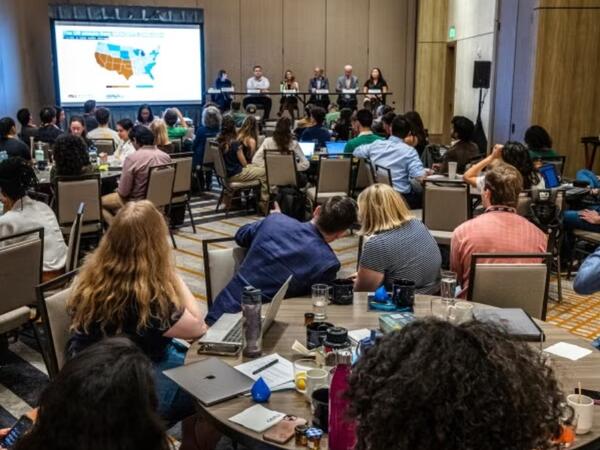 A conference panel in a full room