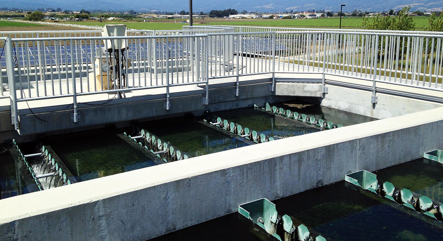 Ponds surrounded by concrete at a water treatment facility.