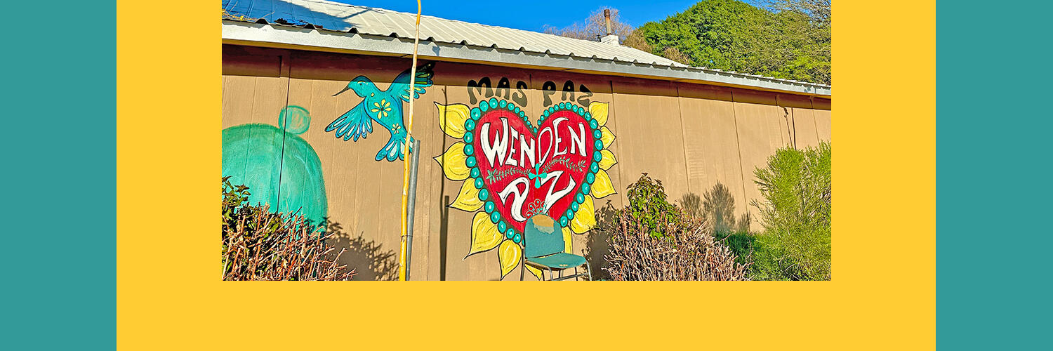 A colorful mural with a large heart in the middle saying "Mas Paz." Photo by Faith Kearns.