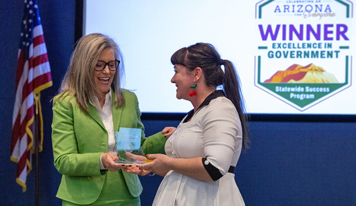 One woman presents another with an award.