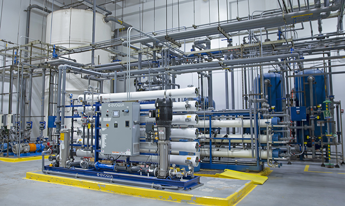 A series of large pipes and tanks in a warehouse setting.