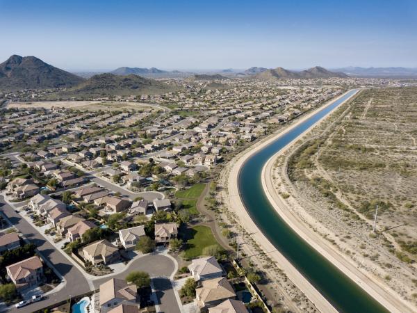 Aerial view of a canal running through a desert suburb.