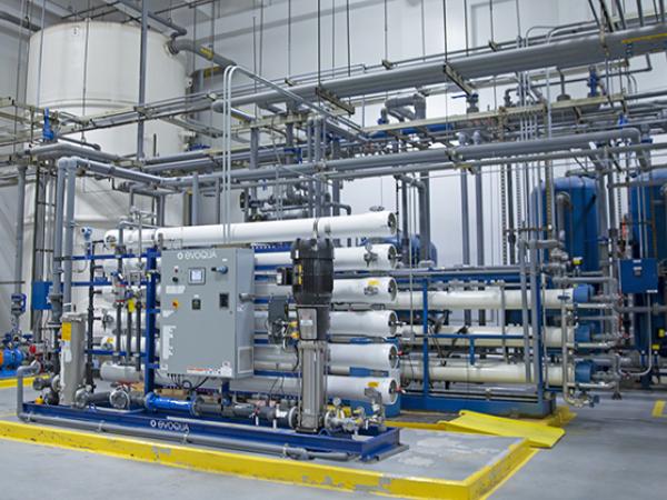 Series of pipes and tanks in a large warehouse setting.