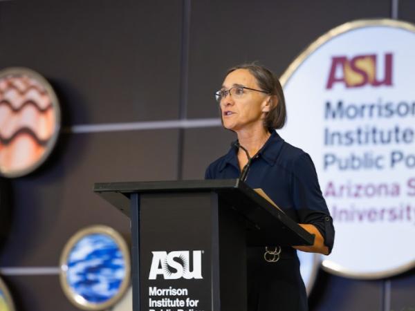 Woman stand speaking at a podium.