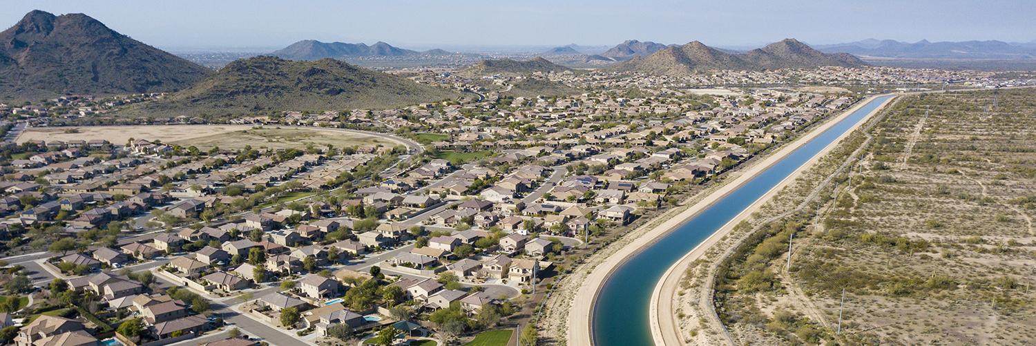 Aerial view of a canal running through a desert suburb.
